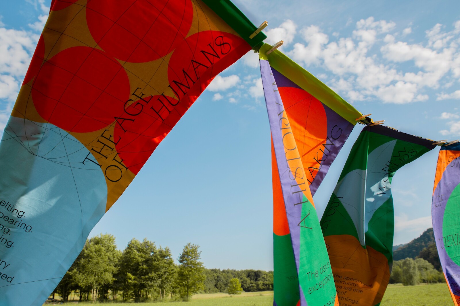 Die Flaggen der aktivistischen Kampagne "Apocalyptic Optimists" tragen Aussagen, die dazu anregen, den Status Quo zu hinterfragen und somit zum Handeln auffordern.